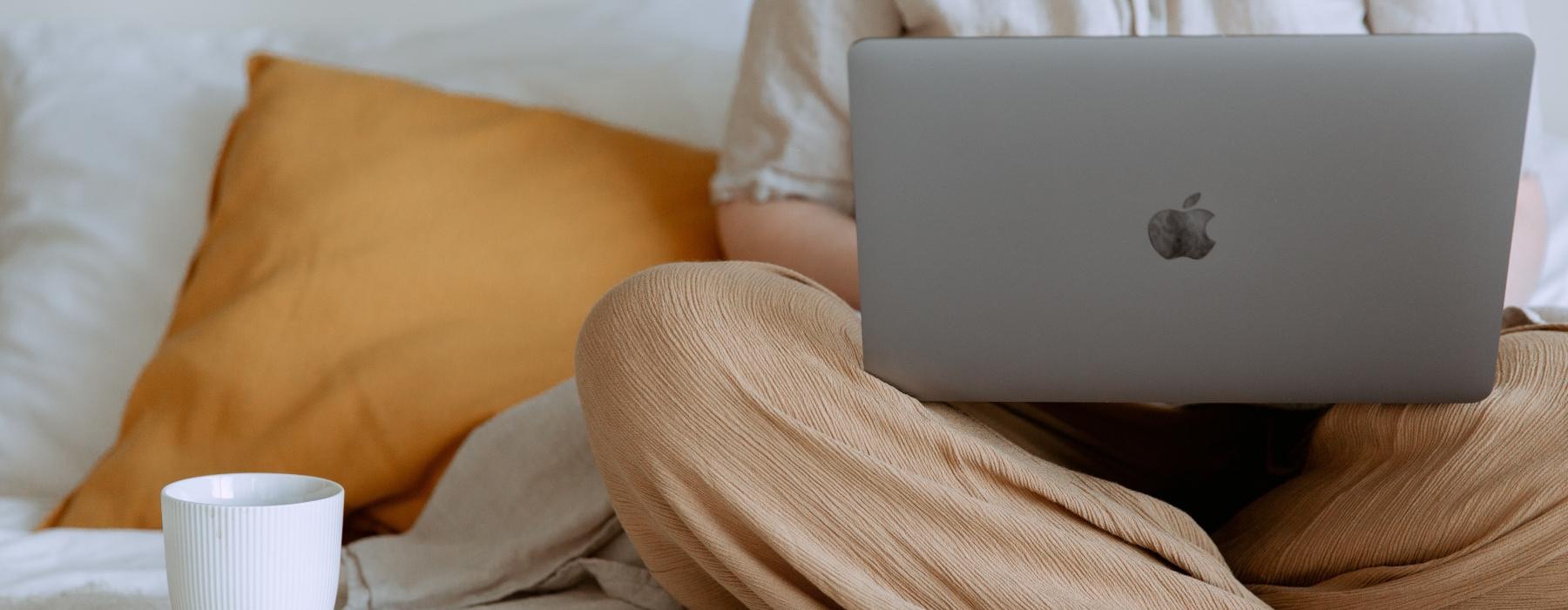 a person with a laptop on a bed